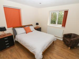 a bedroom with a bed and a chair and a window at Butterfly Lodge in Lincoln