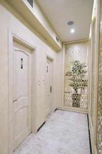 a hallway with white doors and a wall with a window at Hotel Diamantidis in Myrina