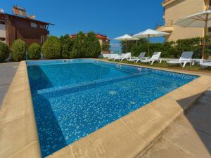 a swimming pool with blue water in front of a house at Hotel Odyssey Sozopol in Sozopol