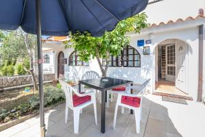 a table and chairs with an umbrella on a patio at Apartmani Nadia in Punat