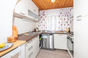 a kitchen with white cabinets and a stainless steel refrigerator at Apartmani Nadia in Punat