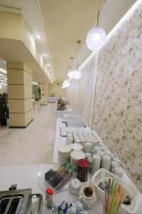 a long line of tables in a room with flowers at Hotel Diamantidis in Myrina