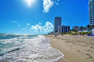 a beach with buildings and the ocean on a sunny day at Dharma Home Suites Miami Beach at Monte Carlo in Miami Beach