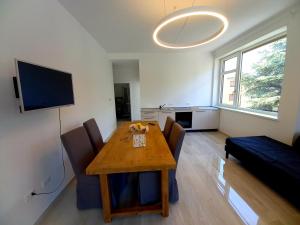 Una sala de estar con una mesa y sillas y un televisor. en Alps Apartments Viktory, en Bolzano