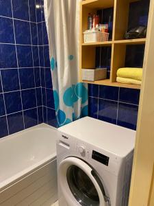 a washing machine in a bathroom with a shower at Oja 134 Apartments in Pärnu