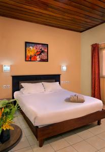 a bed in a room with a large white bed at Dunia Hôtel Bissau in Bissau