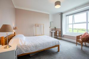 een slaapkamer met een groot bed en een raam bij OA Surf Club in Bude