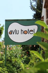 a sign for an ayu hotel in front of some plants at Avlu Hotel in Kemer