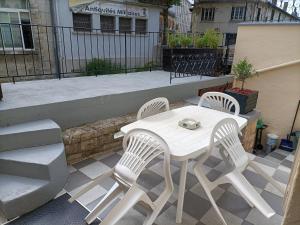 - une table et des chaises blanches sur la terrasse dans l'établissement au chevet des canaux de verdun, à Verdun-sur-Meuse