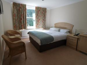 1 dormitorio con cama, escritorio y ventana en The Grove Hotel, en Bournemouth