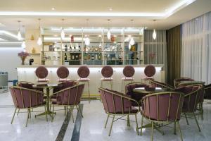 a restaurant with chairs and tables and a bar at Hotel Diamantidis in Myrina