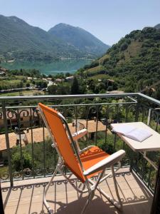 a chair on a balcony with a view of a lake at Casa con terrazzo vista Lago - LAKEHOLIDAY IT in Castel di Tora