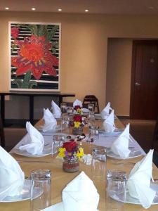 długi stół z białymi serwetkami i kwiatami w obiekcie Los Brezos Hotel Boutique w mieście Volcán