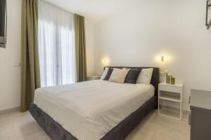 - une chambre avec un grand lit et une fenêtre dans l'établissement Residence Meridian Unità 1, à Villa San Pietro