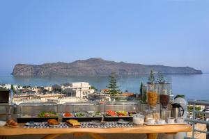 una mesa con comida y vistas al agua en Hermes Sea View, en Stalós