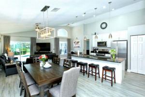 a kitchen and living room with a wooden table and chairs at Splendid Newly Renovated Pool Villa on Golf Course in Haines City