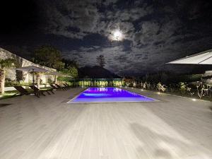 a swimming pool at night with the moon in the sky at CFS Azores Guest House in Ponta Delgada