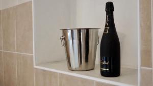 Una botella de champán y un cubo en un estante. en Mlýnský dům, en Hroznětín