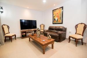 a living room with a leather couch and a coffee table at Hotel Casa Real Piura in Piura