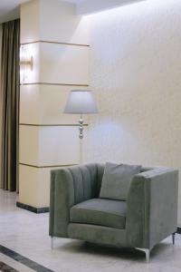 a green couch in a living room with a lamp at Hotel Diamantidis in Myrina