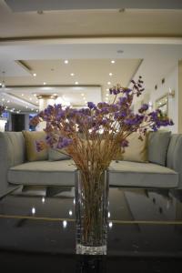 a vase with purple flowers sitting on a table at Hotel Diamantidis in Myrina