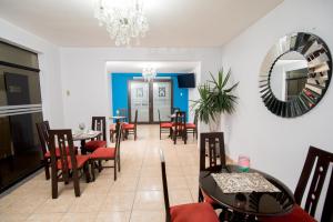 a dining room with tables and chairs and a mirror at Hotel Casa Real Piura in Piura