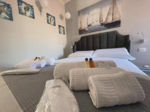a bedroom with a large bed with towels on it at Las Floridas Apartment in Alghero