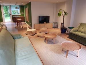 a living room with a couch and tables and a tv at Micampus Bilbao Student Residence in Bilbao