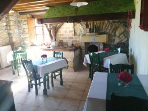 a restaurant with tables and chairs and a fireplace at Casa Barreta in Villaviciosa