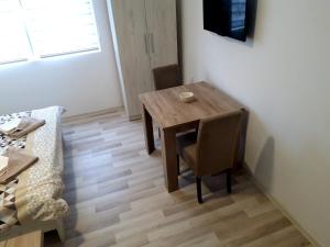 a dining room table with two chairs and a television at Studio north star in Soko Banja