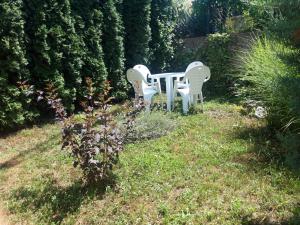 two white chairs and a table in a garden at Studio north star in Soko Banja