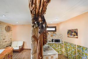 una cocina con un árbol en el medio de una habitación en Appartamento vista incantevole Domm'e Orrosaria, en Baunei