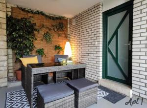 a patio with a table and chairs on a brick wall at Apartments Kolenc in Portorož