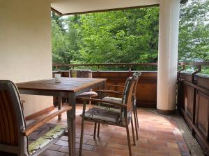 une terrasse couverte avec une table et des chaises. dans l'établissement Ferienwohnung Runca, à Flims