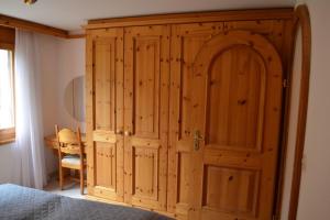 a wooden cabinet in a bedroom with a bed at Ferienwohnung Runca in Flims