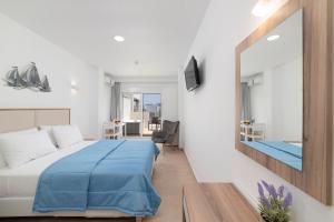 una camera d'albergo con letto e specchio di Naiades Village Elounda a Eloúnda