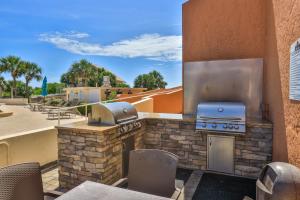 a outdoor patio with a grill and a stove at New Owner Offering Renovated Condo in New Smyrna Beach! 7 day minimum in New Smyrna Beach