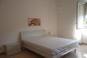 a white bedroom with a bed and a window at maison jolie - Agropoli da vivere- in Agropoli