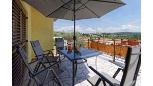 einen Tisch und Stühle mit Sonnenschirm auf dem Balkon in der Unterkunft Holiday Home Vlady in Buje