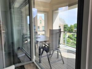 a balcony with a table and chairs on a deck at Penthouse Gezeitenblick, Am Alten Deich 4-2 31 in Dangast