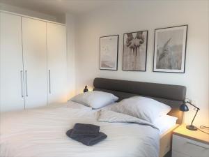 a bedroom with a large white bed with two pillows at Penthouse Gezeitenblick, Am Alten Deich 4-2 31 in Dangast