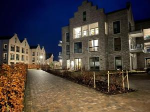 a brick walkway in front of a building at night at Penthouse Gezeitenblick, Am Alten Deich 4-2 31 in Dangast