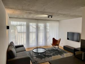 a living room with a couch and a table at City Apartments Kaiserslautern in Kaiserslautern