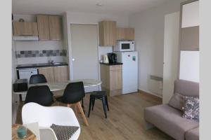 eine Küche und ein Wohnzimmer mit Tisch und Stühlen in der Unterkunft Appart montagne 3 étoiles Saint-Lary station in Saint-Lary-Soulan