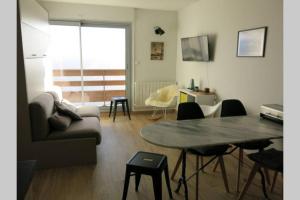 sala de estar con mesa y sofá en Saint-Lary-Soulan 1700, calme, ski, vtt et rando, en Saint-Lary-Soulan