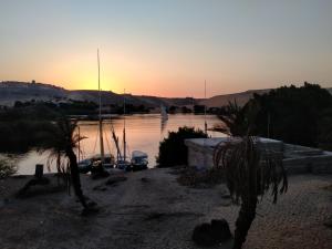 a sunset over a river with boats in it at Seko Kato Nile View Hostel in Aswan
