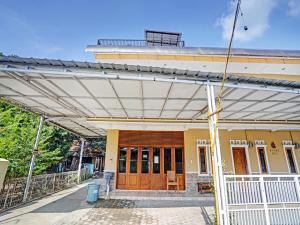 ein Haus mit einer Markise über der Eingangstür in der Unterkunft OYO 90416 Wisma Wayang Ajen Syariah in Subang