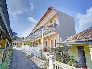 a row of houses in a street with a fence at OYO 90416 Wisma Wayang Ajen Syariah in Subang