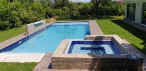 a large swimming pool in a yard with a lawn sidx sidx at Villa Gabriela in Agua de Dios