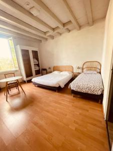 een slaapkamer met 2 bedden en een houten vloer bij Hôtel et RESTAURANT traditionnel L' Escalandes in Lesperon
